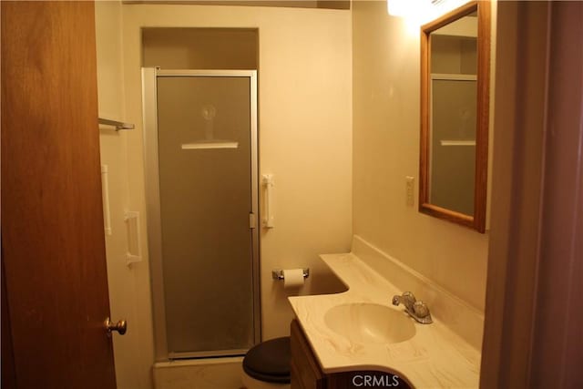 bathroom featuring a stall shower, vanity, and toilet