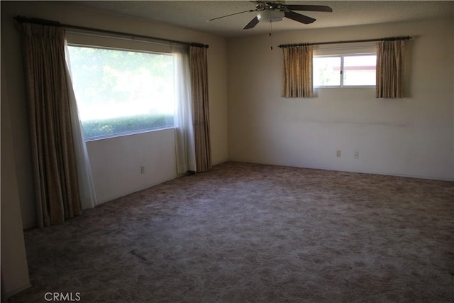 carpeted spare room with a ceiling fan