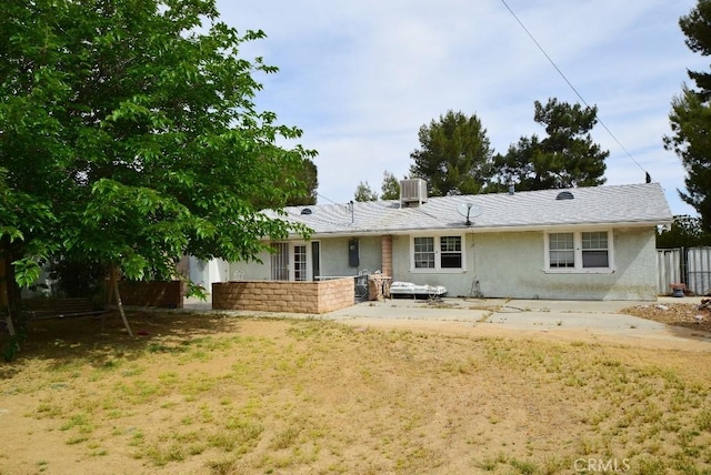 back of property featuring stucco siding, fence, and central AC