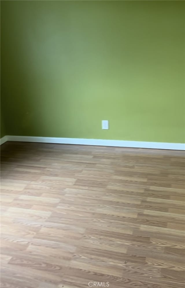 empty room featuring baseboards and wood finished floors