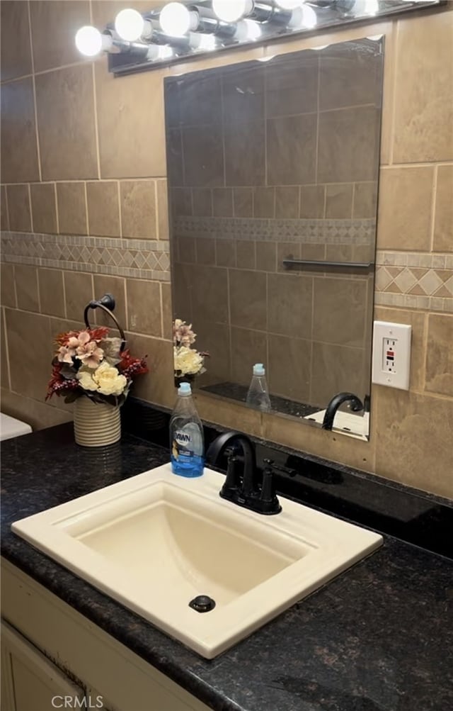 bathroom featuring vanity, tile walls, and tasteful backsplash