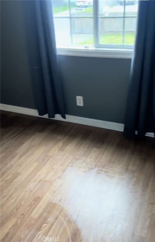 empty room featuring wood finished floors and baseboards
