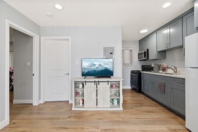 1301 E Pacific Coast, Wilmington, CA 90744 - kitchen with black gas range, stainless steel microwave, gray cabinetry, a sink, and freestanding refrigerator