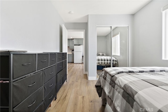 1301 E Pacific Coast, Wilmington, CA 90744 - bedroom with freestanding refrigerator, light wood-style flooring, a closet, and baseboards