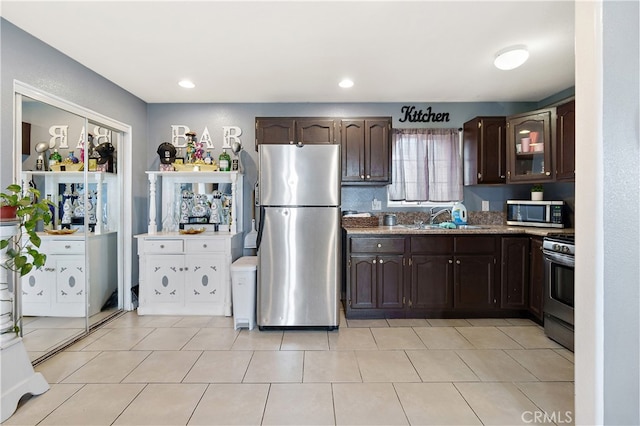 1301 E Pacific Coast, Wilmington, CA 90744 - kitchen with appliances with stainless steel finishes, a sink, dark brown cabinetry, stone counters, and glass insert cabinets