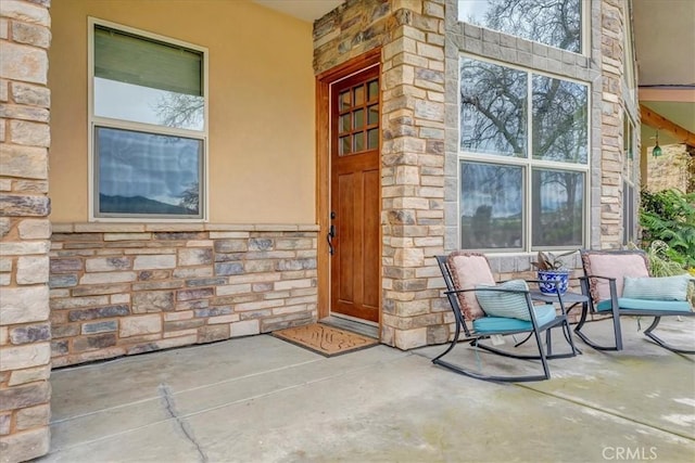 property entrance with stone siding and stucco siding