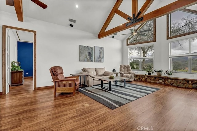 living room with beam ceiling, wood finished floors, ceiling fan, and high vaulted ceiling