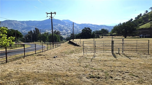 exterior space with fence, a rural view, a mountain view, and an enclosed area