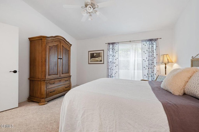 bedroom featuring light colored carpet, vaulted ceiling, and a ceiling fan