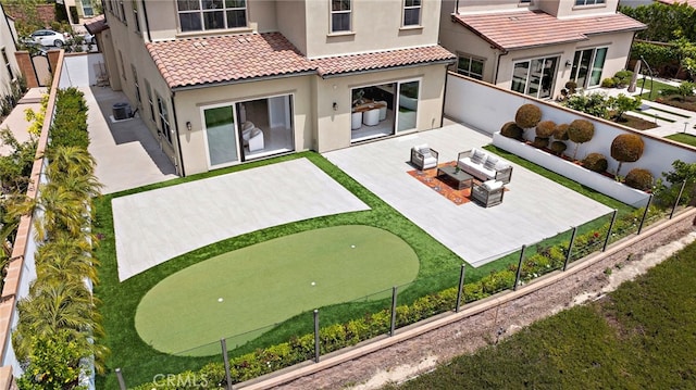 109 Chronology, Irvine, CA 92618 - rear view of property with stucco siding, an area to practice putting, a patio, a tile roof, and central AC unit