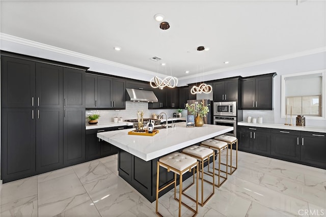 109 Chronology, Irvine, CA 92618 - kitchen featuring stainless steel appliances, under cabinet range hood, dark cabinets, a breakfast bar area, and light marble finish flooring
