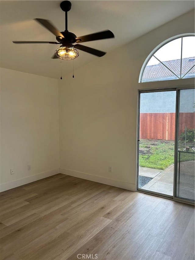 unfurnished room featuring light wood finished floors, baseboards, and a ceiling fan