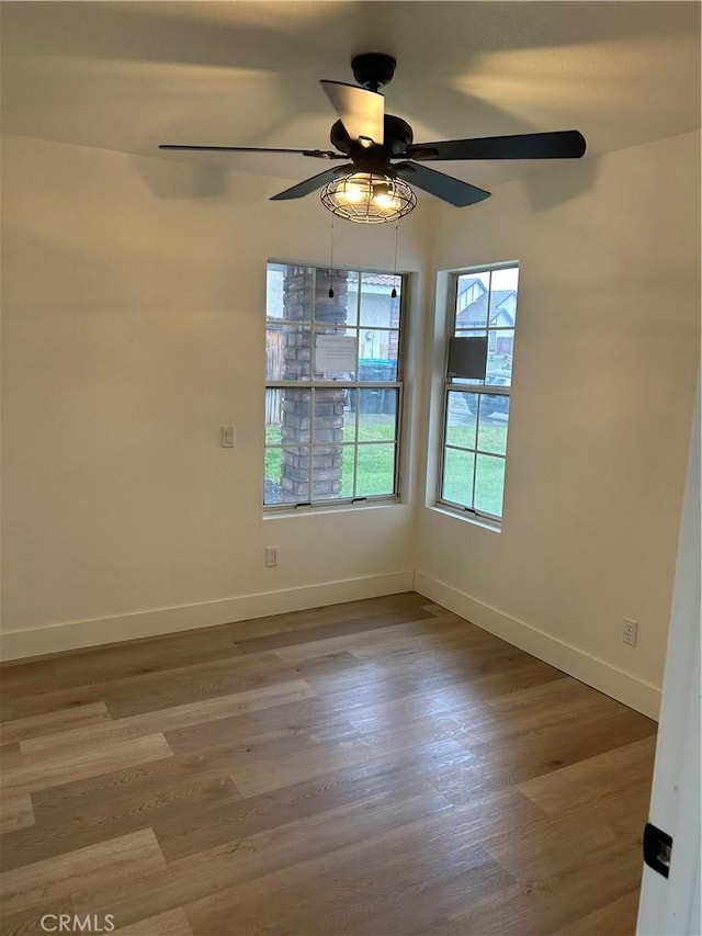 spare room featuring baseboards, a ceiling fan, and wood finished floors