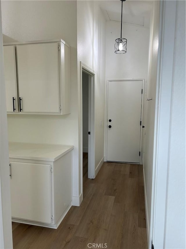 hallway with attic access, baseboards, and wood finished floors