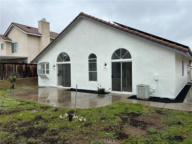 back of property featuring central AC unit, a patio, a tiled roof, and fence