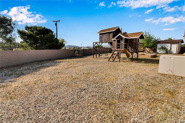 18343 Cocopah Ct, Apple Valley, CA 92307 - view of yard with a fenced backyard, an outdoor structure, a storage shed, and a playground