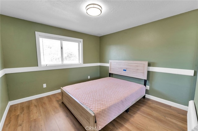 18343 Cocopah Ct, Apple Valley, CA 92307 - bedroom with baseboards, wood finished floors, and baseboard heating