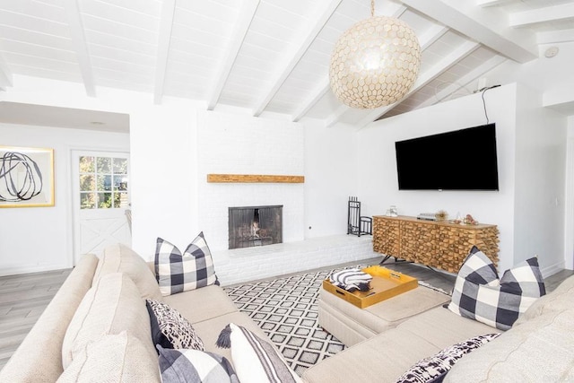 living area featuring a fireplace, lofted ceiling with beams, and wood finished floors