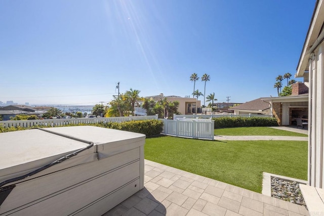 view of patio / terrace with a hot tub and fence