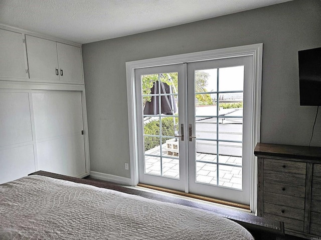bedroom with baseboards, access to outside, french doors, and a closet