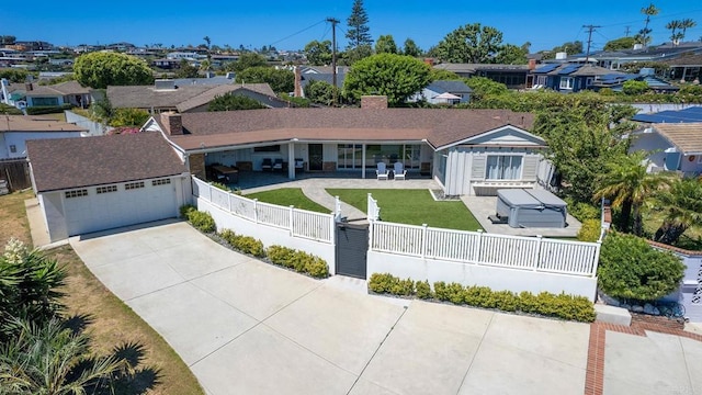 ranch-style home featuring a patio, a residential view, a front lawn, driveway, and fence private yard