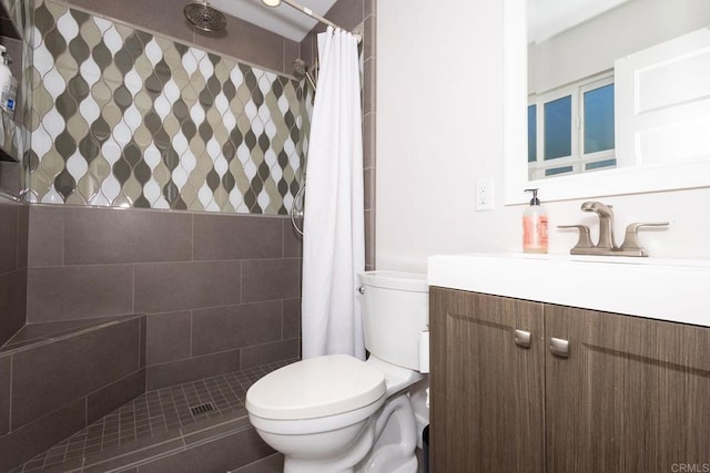full bathroom with toilet, tiled shower, and vanity