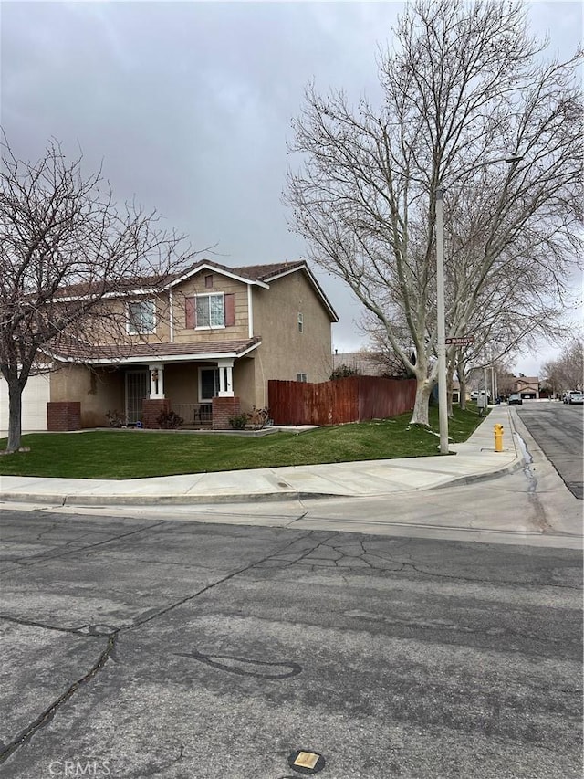 exterior space with stucco siding, fence, and a lawn