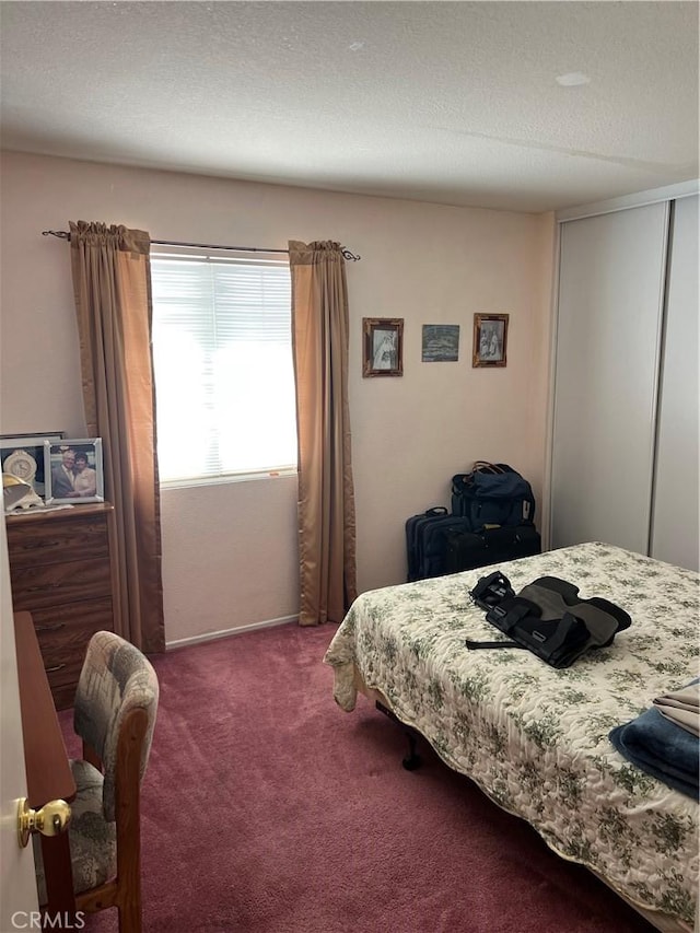 bedroom featuring a textured ceiling, carpet flooring, and a closet