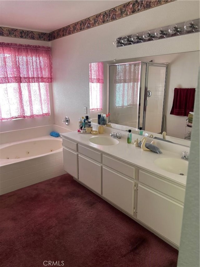 bathroom featuring a sink, double vanity, a jetted tub, and a shower with shower door
