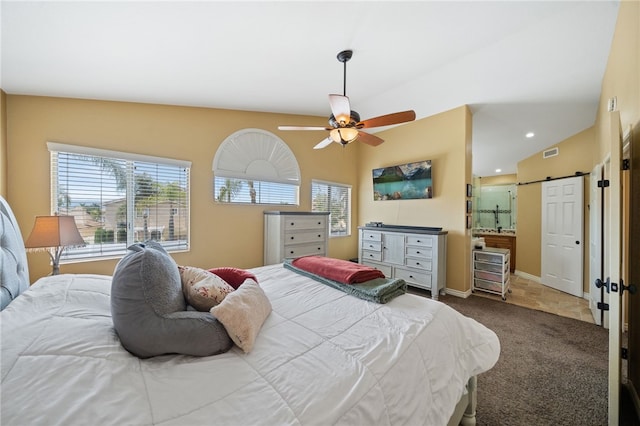 bedroom with a barn door, visible vents, ceiling fan, carpet floors, and baseboards