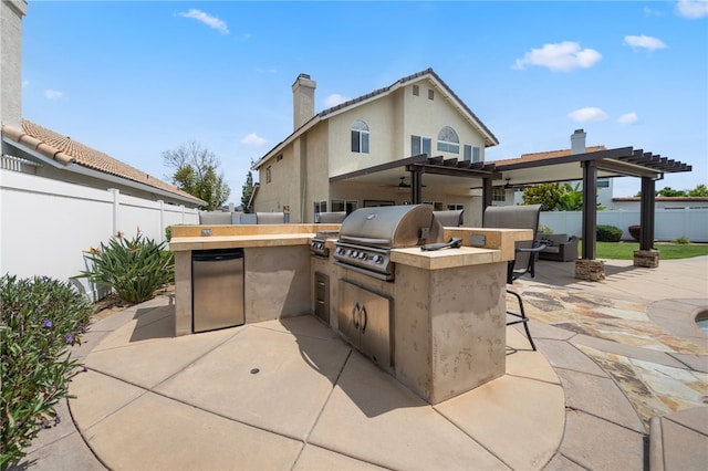 view of patio featuring area for grilling, a fenced backyard, and exterior kitchen