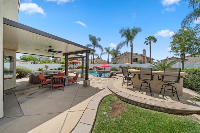 view of patio with a ceiling fan, a fenced in pool, a fenced backyard, and outdoor dry bar