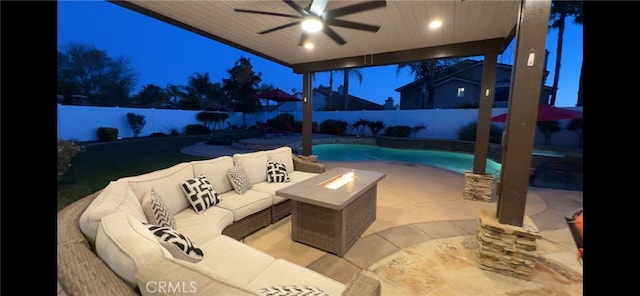 patio at night featuring a fenced backyard, an outdoor living space with a fire pit, a fenced in pool, and a ceiling fan