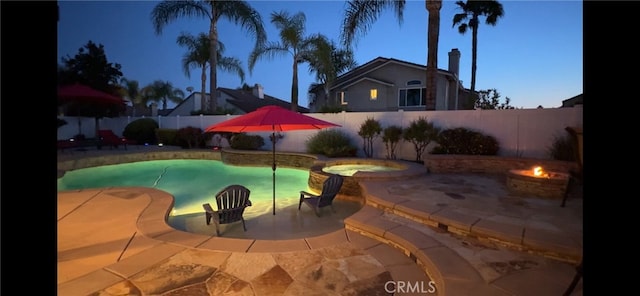 view of pool featuring a fire pit, a patio, an in ground hot tub, and a fenced backyard