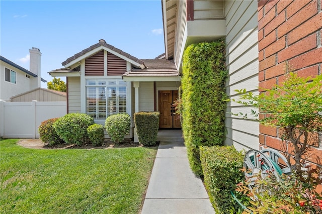 property entrance with a yard and fence