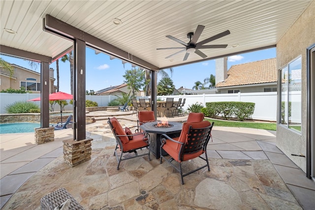 view of patio with a fenced backyard, an outdoor fire pit, a fenced in pool, and ceiling fan