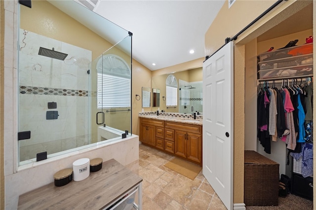 bathroom with double vanity, a stall shower, stone finish flooring, lofted ceiling, and recessed lighting