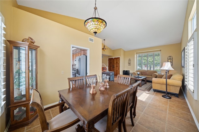 dining room with lofted ceiling, baseboards, light tile patterned floors, and visible vents