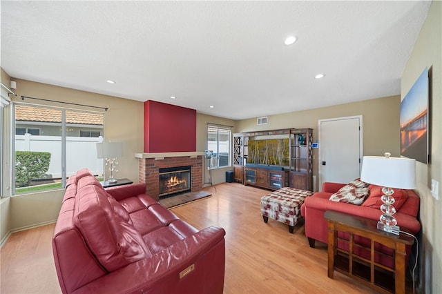 living room featuring visible vents, wood finished floors, a fireplace, and recessed lighting
