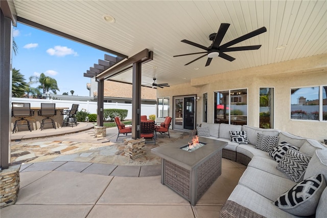 view of patio with an outdoor living space with a fire pit, fence, outdoor dining area, and a ceiling fan