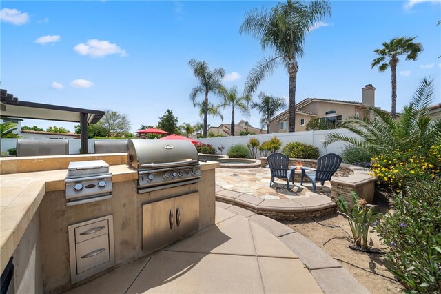 view of patio / terrace featuring a grill, area for grilling, fence private yard, and a fire pit