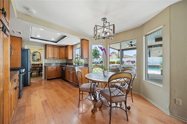 dining room with light wood-style flooring, a wealth of natural light, a notable chandelier, and visible vents