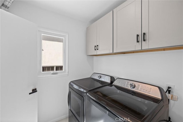 laundry area with separate washer and dryer and cabinet space