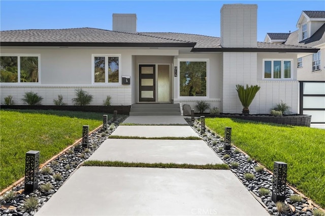 ranch-style house featuring a chimney and a front yard