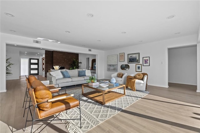 living area featuring recessed lighting, visible vents, and wood finished floors