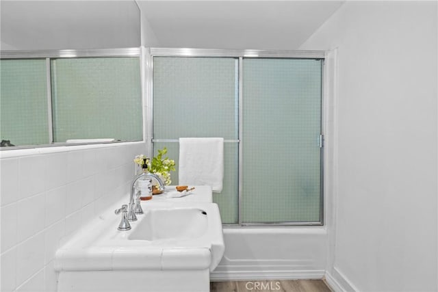 full bathroom with wood finished floors and shower / bath combination with glass door