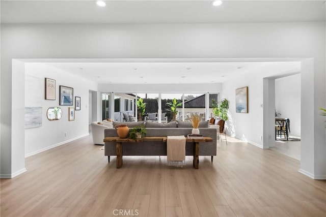 living area featuring light wood-style flooring, baseboards, and recessed lighting