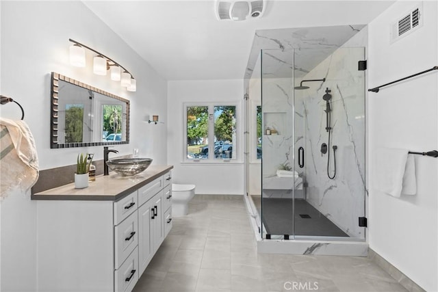 full bath with toilet, vanity, a marble finish shower, visible vents, and baseboards