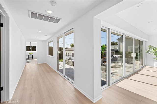 corridor featuring light wood-type flooring, recessed lighting, baseboards, and visible vents