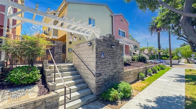 1500 Pine Ave Unit 19, Long Beach, CA 90813 - view of front of house with stone siding, stucco siding, and a pergola